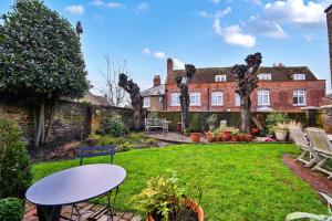 a garden with a table and chairs in a yard at Finest Retreats - St Germains Annexe in Sandwich