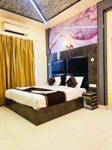 a bedroom with a large bed with a painting on the wall at Hotel HSP Suites - Near IGI Airport, New Delhi in New Delhi
