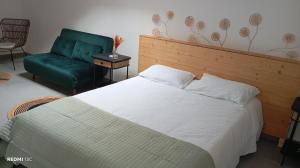 a bedroom with a bed and a green chair at le Cocon du Causse in Causse-de-la-Selle +15 photos