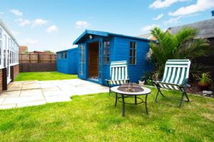 two chairs and a table in a yard with a blue house at 2 Bed in Walcott oc-2209 in Walcott