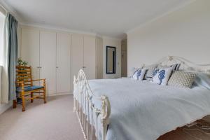 a bedroom with a white bed and a chair at 3 Bed in Cley oc-2122 in Cley next the Sea