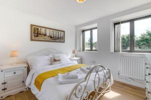 a white bedroom with a white bed and windows at 3 Bed in Shereford oc-2173 in Tatterford