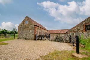 an old stone barn with a gate in front of it at 3 Bed in Shereford oc-2173 in Tatterford