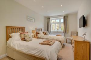 a bedroom with two beds and a desk and a television at 3 Bed in Elsing oc-1973 in Elsing