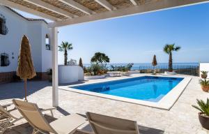 a villa with a swimming pool with chairs and the ocean at Finca Sol y Cielo in Cajís