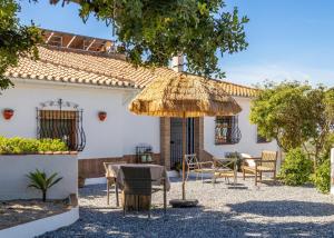 a patio with a table and chairs and an umbrella at Finca Sol y Cielo in Cajís