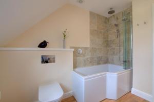 a white bathroom with a shower and a tub at 2 Bed in Blakeney oc-1558 in Blakeney +13 photos