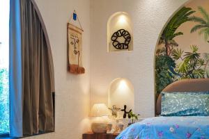 a bedroom with a bed and a clock on the wall at Zoe Cozy Escape with Big Projector in Amritsar