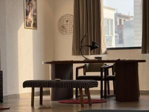 a desk and a bench in a room with a window at Zoe Cozy Escape with Big Projector in Amritsar +10 photos