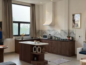 a kitchen with a table in the middle of a room at Zoe Cozy Escape with Big Projector in Amritsar