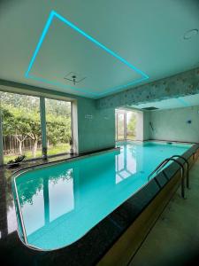 a large indoor swimming pool with a blue ceiling at Antano sodyba in Dauparai