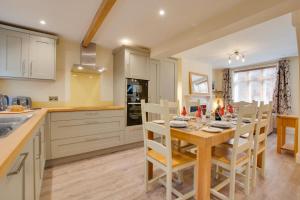 a kitchen with a wooden table with chairs and a dining room at 3 Bed in Sheringham oc-2170 in Sheringham