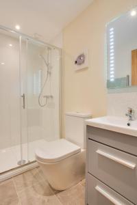 a bathroom with a toilet and a shower and a sink at 3 Bed in Sheringham oc-2170 in Sheringham +9 photos