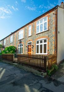 a brick house with a fence in front of it at 3 Bed in Sheringham oc-2170 in Sheringham