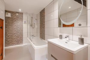a white bathroom with a sink and a mirror at 2 Bed in Swimbridge oc-n0209 in Swimbridge +14 photos