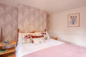 a bedroom with a bed with white sheets and floral wallpaper at 2 Bed in Swimbridge oc-n0209 in Swimbridge