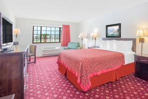 a hotel room with a bed and a flat screen tv at Days Inn by Wyndham Lake Village in Lake Village