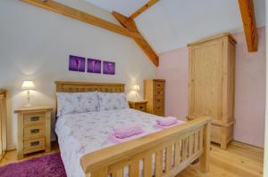a bedroom with a wooden bed with pink towels on it at 1 Bed in Tiverton oc-gear in Bampton
