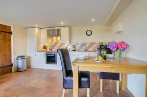a kitchen with a wooden table and black chairs at 1 Bed in Tiverton oc-gear in Bampton