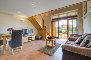 a living room with a couch and a table and a television at 1 Bed in Tiverton oc-gear in Bampton