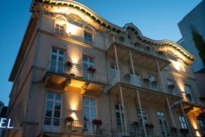a large white building with balconies and lights at Parkhotel Bad Homburg in Bad Homburg vor der Höhe
