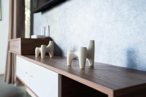 a wooden table with two white sculptures on it at Résidence Luxe avec Plage Privée in Bouznika