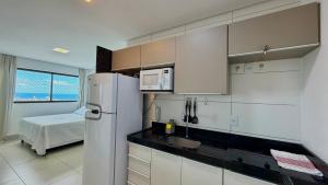 a kitchen with a refrigerator and a bed in a room at Flat Ilha do Leite in Recife