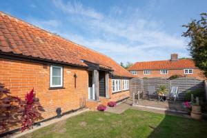 a brick house with a patio and a fence at 1 Bed in Saxtead oc-sfmhf in Saxtead