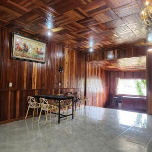 a dining room with wooden walls and a table and chairs at DalatXCamp Nystay in Ấp Kim Thạch