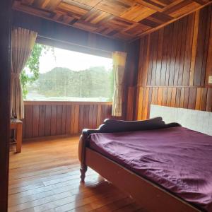 a bed in a room with a large window at DalatXCamp Nystay in Ấp Kim Thạch