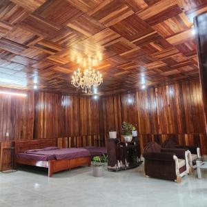 a large room with a bed and a chandelier at DalatXCamp Nystay in Ấp Kim Thạch