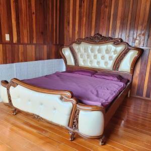 a bed with a white frame and purple sheets at DalatXCamp Nystay in Ấp Kim Thạch