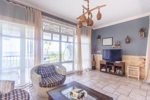 a living room with a large window and a tv at Los Balcones, Sosua, Ocean Front! in Sosúa