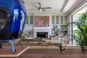 a living room with a fireplace and a ceiling fan at Plett Azure Guesthouse in Plettenberg Bay