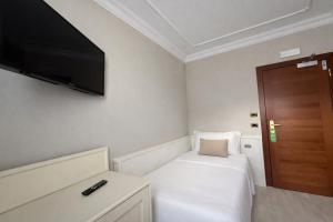 a small room with a bed and a flat screen tv at Hotel President Venezia in Mestre