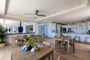 a dining room and kitchen with wooden tables and chairs at Plett Azure Guesthouse in Plettenberg Bay
