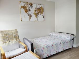 a bedroom with a bed and a chair and a map at Modern town centre apartment in Tobercurry