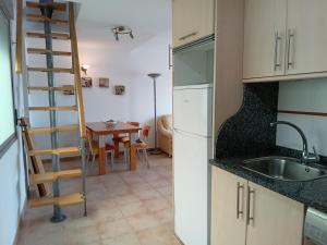 a kitchen with a sink and a ladder next to a table at Piso Adrian in Sierra de Outes