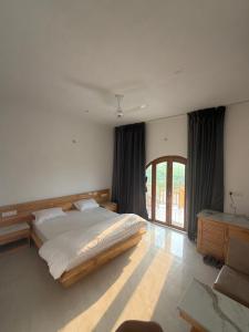 a bedroom with a large bed and a window at The Tarai Pilibhit in Kālīnagar +16 photos