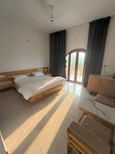 a bedroom with a bed and a large window at The Tarai Pilibhit in Kālīnagar