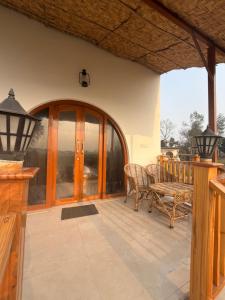 a porch with a glass door and a bench at The Tarai Pilibhit in Kālīnagar