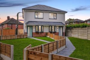 a house with a fence in front of a yard at Ideal Lodgings in Radcliffe in Radcliffe