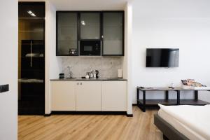 a white kitchen with a sink and a tv at Mountain Residence Apartments & Chalet in Bukovel +103 photos