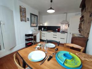 a kitchen with a wooden table with blue plates on it at Le toit de Veules - Proche Mer - Veules les Roses in Veules-les-Roses +13 photos
