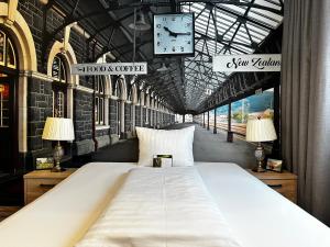 a large bed in a train station with a clock at Designhotel Central Fulda in Fulda