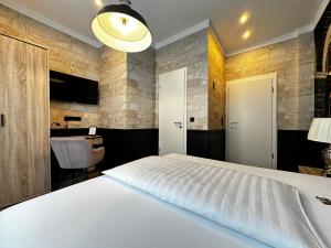 a bedroom with a white bed and a desk at Designhotel Central Fulda in Fulda
