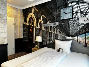 a bedroom with a bed and a clock on the wall at Designhotel Central Fulda in Fulda