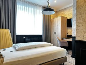 a hotel room with a bed and a desk at Designhotel Central Fulda in Fulda +124 photos