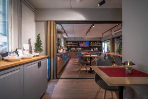 a restaurant with a bar with tables and chairs at Hotel Jokipuisto in Kotka