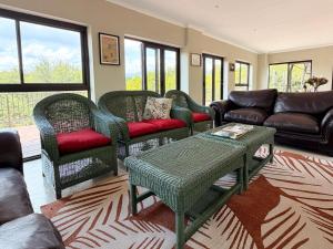 a living room with wicker chairs and a couch at Meulensrus in Hoedspruit